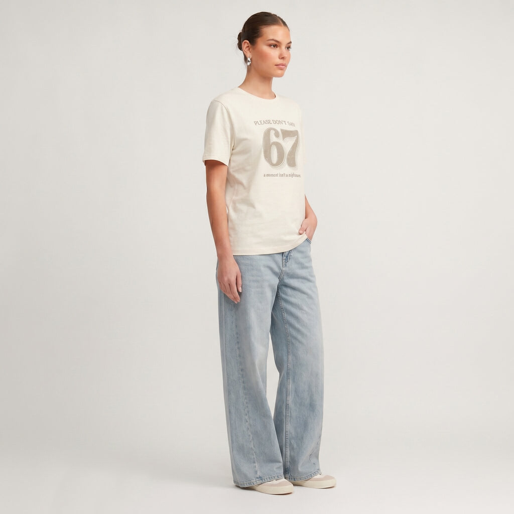 Kiksy cream funny mum t-shirt featuring the slogan Please don't say 67 a mum's worst nightmare, modelled by a woman.