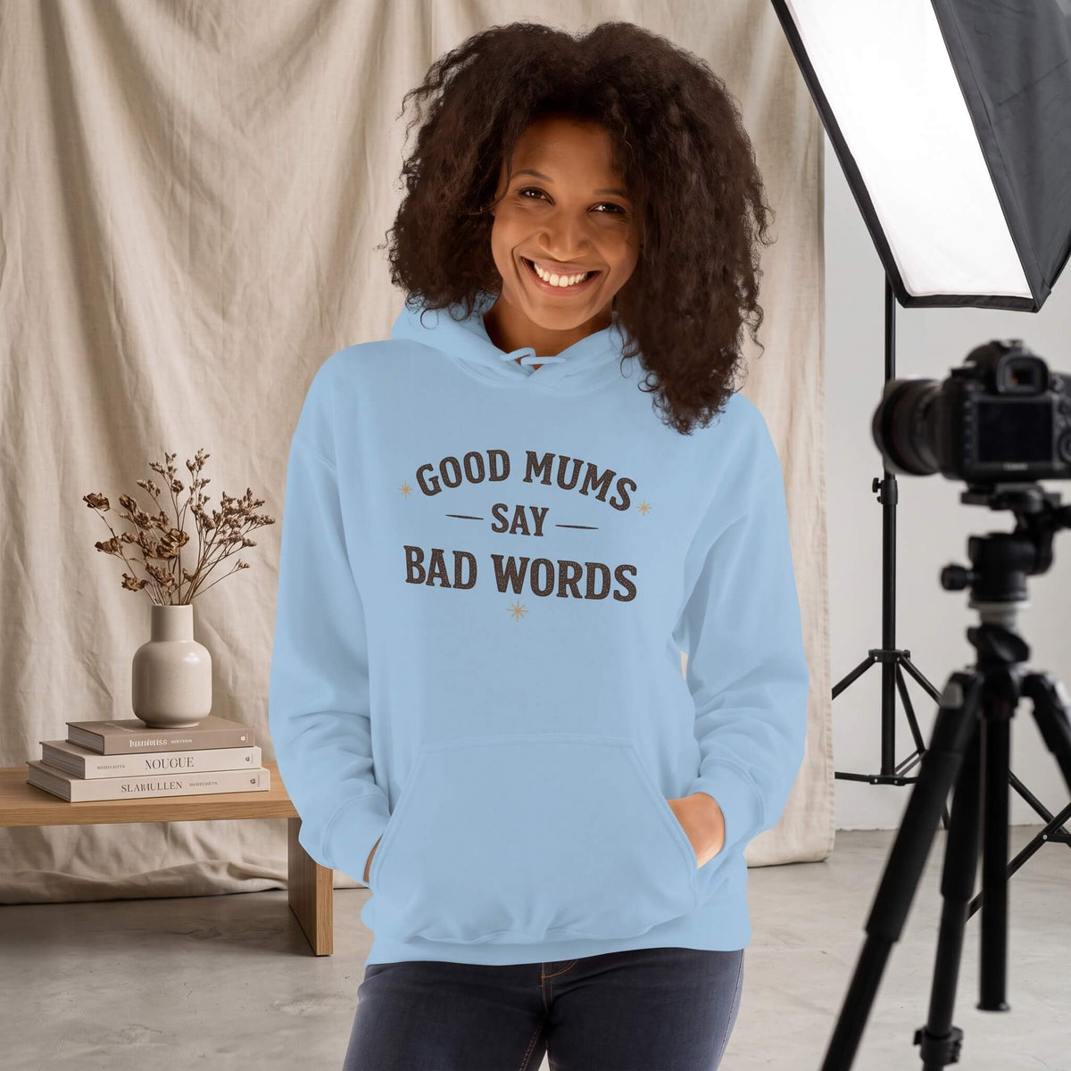 Kiksy sky blue hoodie with Good Mums Say Bad Words printed on the front worn by a smiling woman