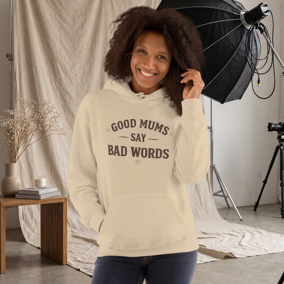 Kiksy nude hoodie with Good Mums Say Bad Words printed on the front worn by a smiling woman