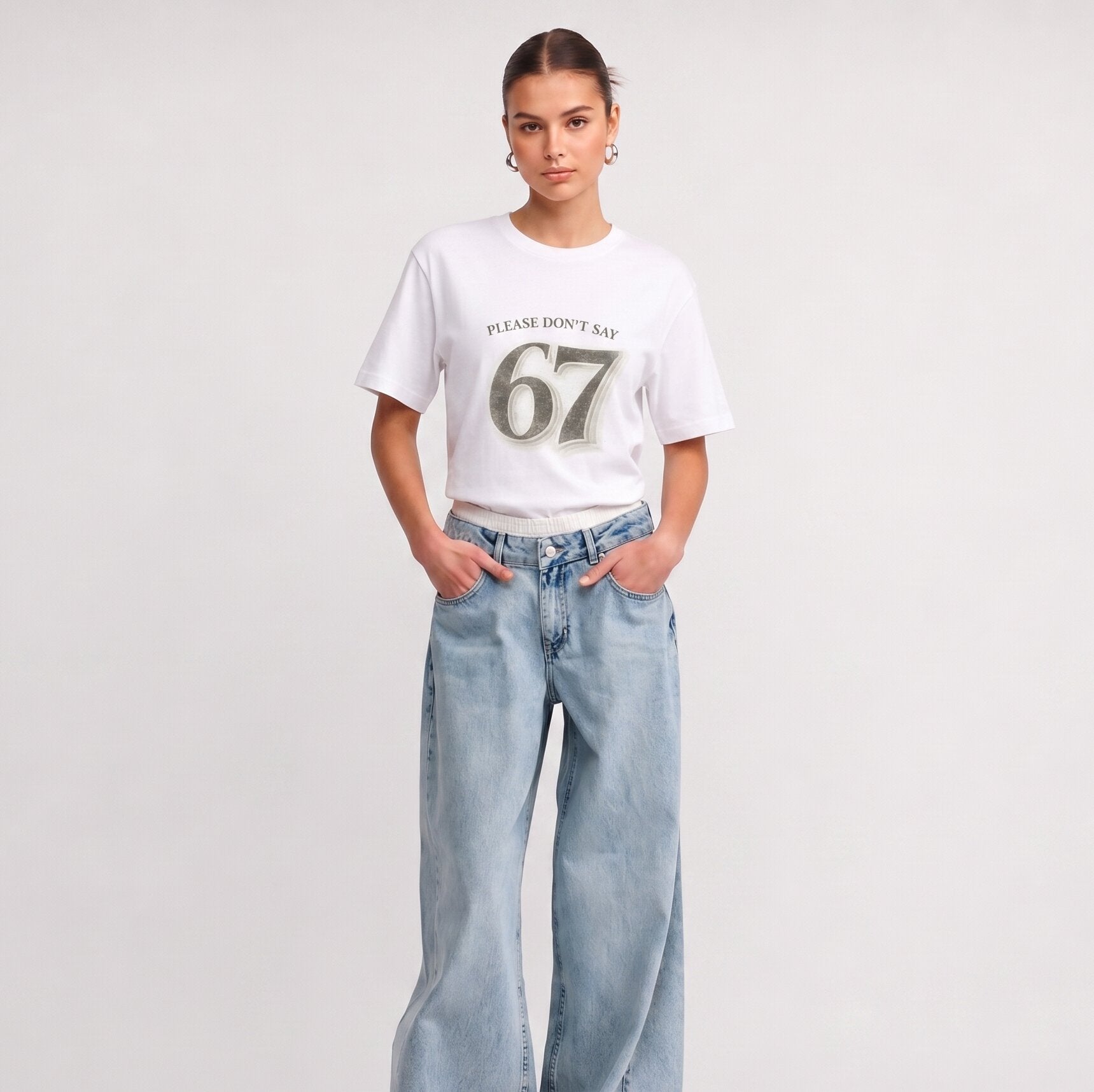 Woman wearing Kiksy white relaxed slogan t-shirt featuring Please Don't Say 67 print with casual blue jeans.