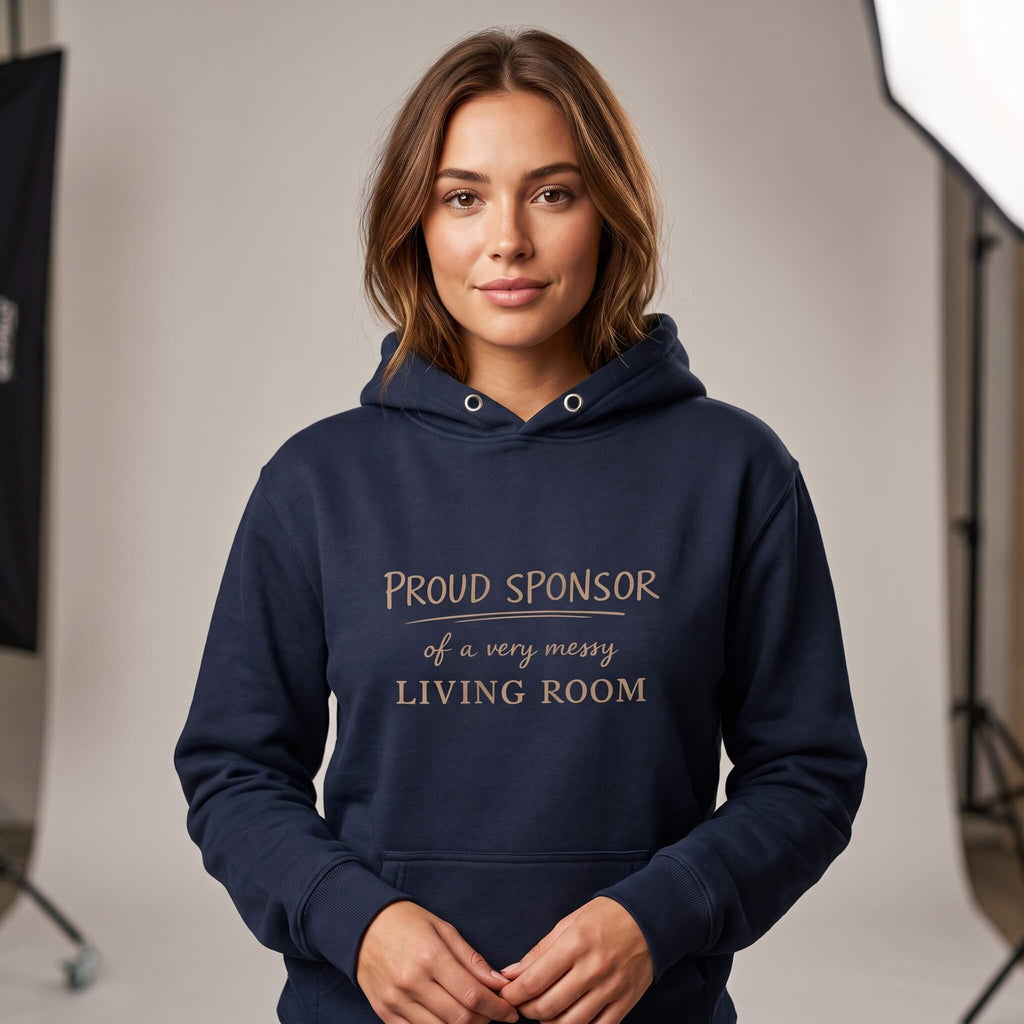 Woman wearing Kiksy dark blue hoodie featuring the text Proud Sponsor of a very messy LIVING ROOM