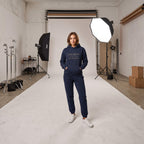 Woman wearing Kiksy dark blue hoodie featuring the text Proud Sponsor of a very messy LIVING ROOM