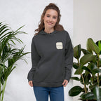 Woman smiling in a Kiksy charcoal grey hoodie featuring a cream square MAMA chest logo.