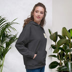 Woman smiling in a Kiksy charcoal grey hoodie featuring a cream square MAMA chest logo.