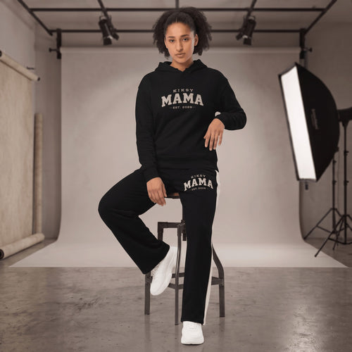 Kiksy black wide leg mama joggers with white side stripes and collegiate print, worn by a smiling model in a studio.