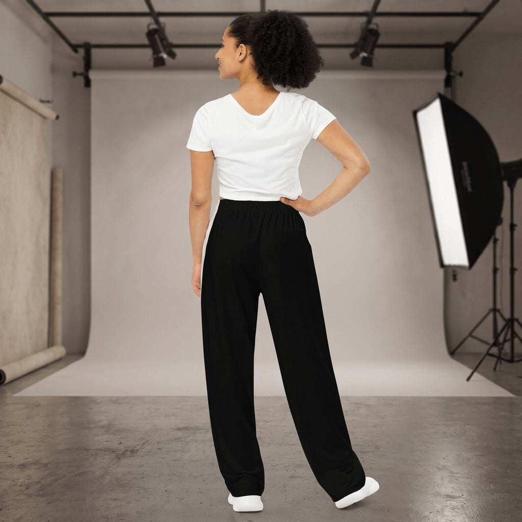 Kiksy black wide leg mama joggers with white side stripes and collegiate print, worn by a smiling model in a studio.