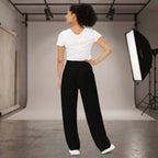 Kiksy black wide leg mama joggers with white side stripes and collegiate print, worn by a smiling model in a studio.