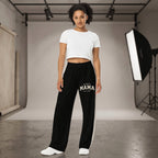 Kiksy black wide leg mama joggers with white side stripes and collegiate print, worn by a smiling model in a studio.