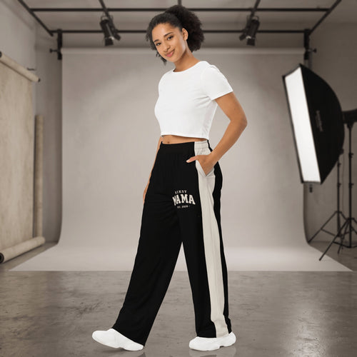 Kiksy black wide leg mama joggers with white side stripes and collegiate print, worn by a smiling model in a studio.